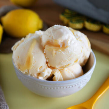 Scoops of lemon curd ice cream in a small white bowl.
