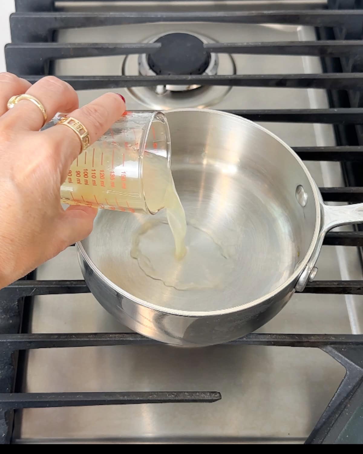 Pouring lemon juice into a saucepan.