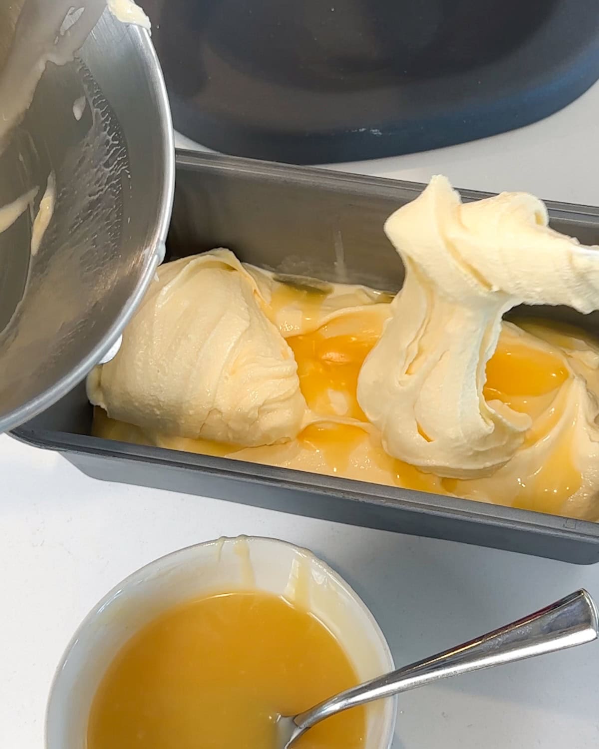 Adding scoops of lemon ice cream on top of a lemon curd layer.