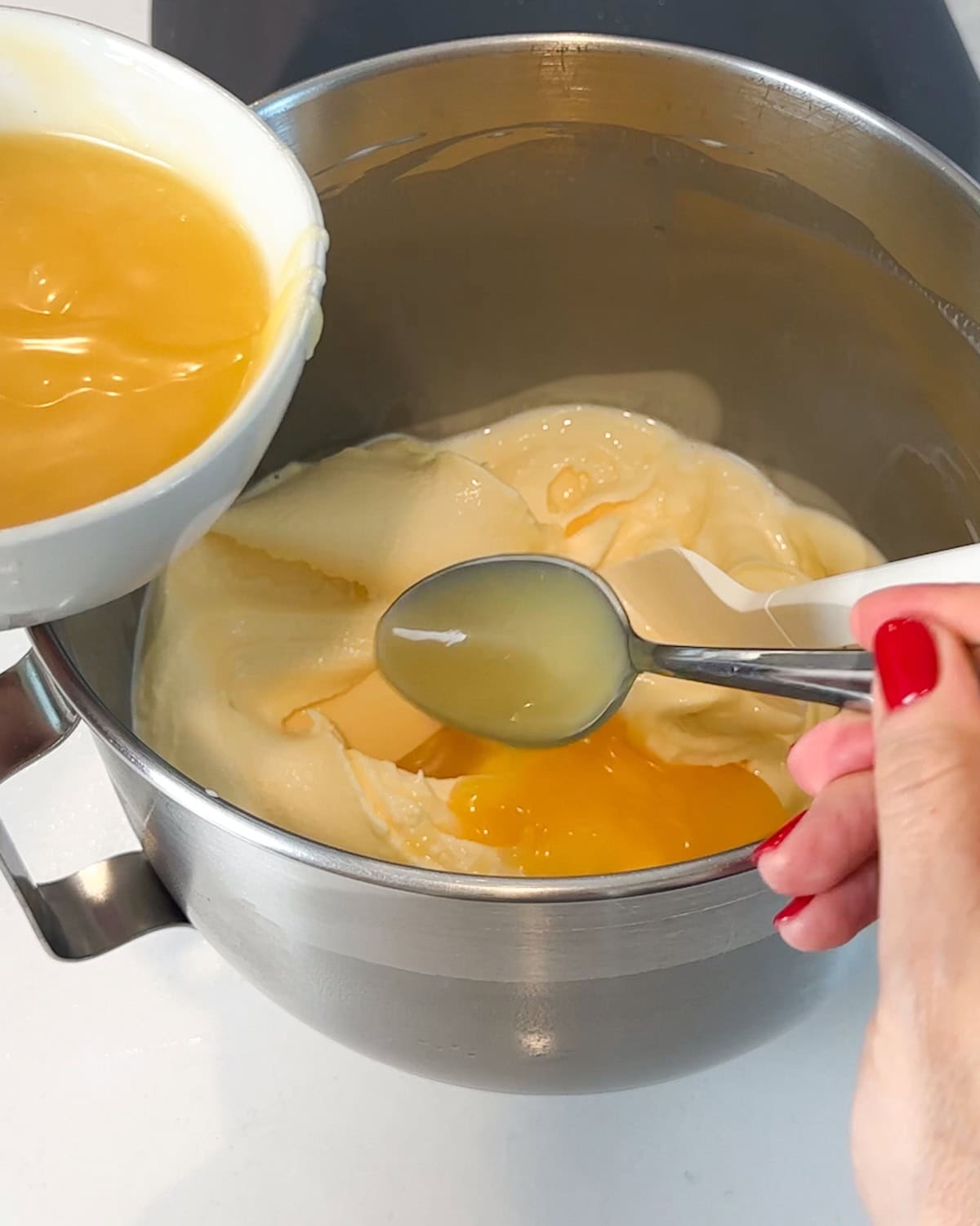 Adding lemon curd to softened ice cream.