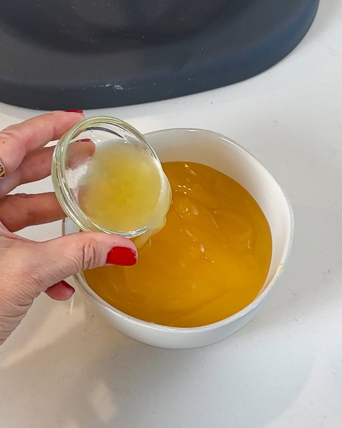 Mixing lemon juice into lemon curd.