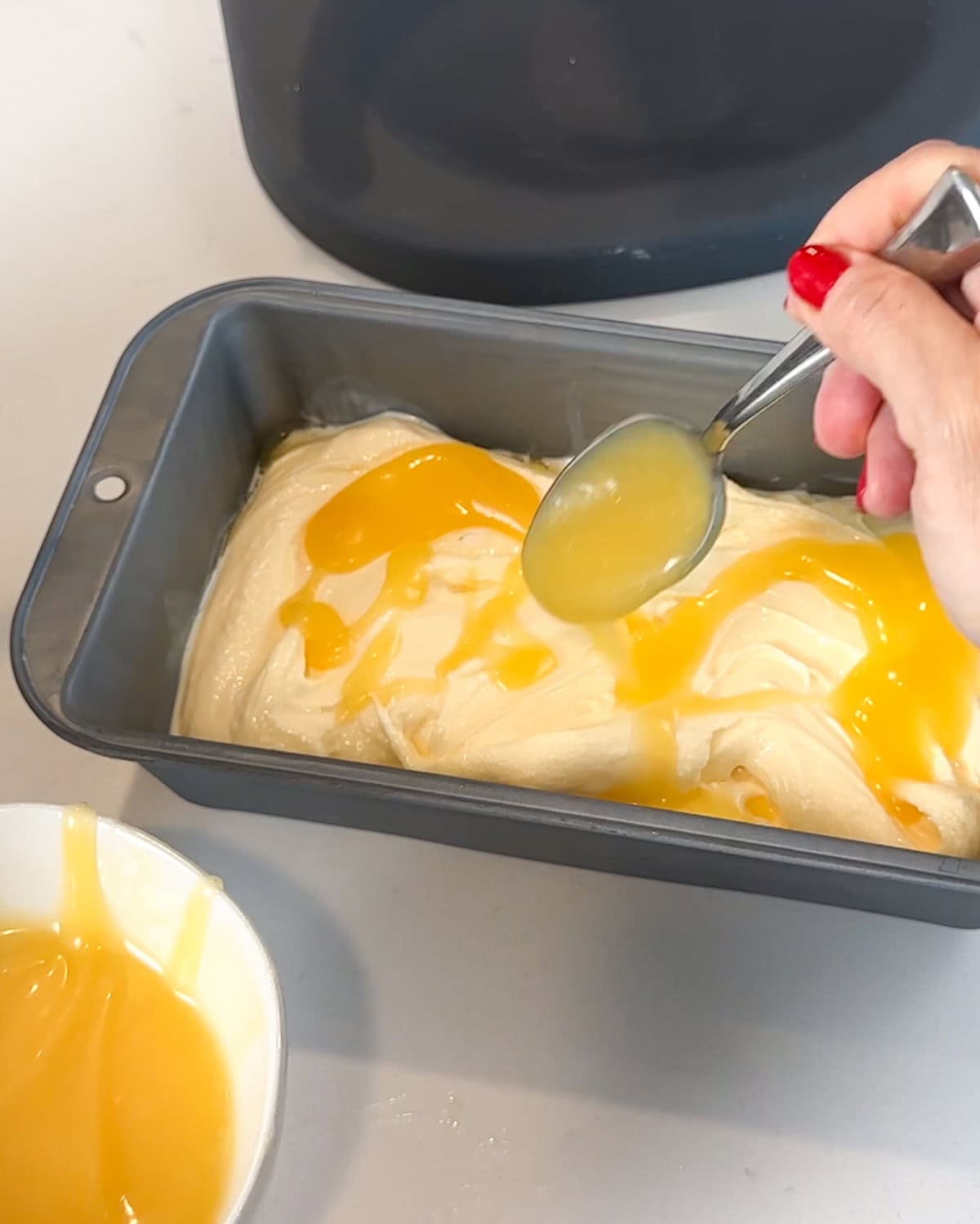 Adding a second layer of lemon curd on top of lemon ice cream.