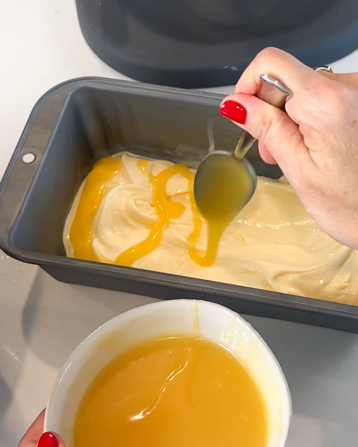 Layering lemon curd on top of lemon ice cream.