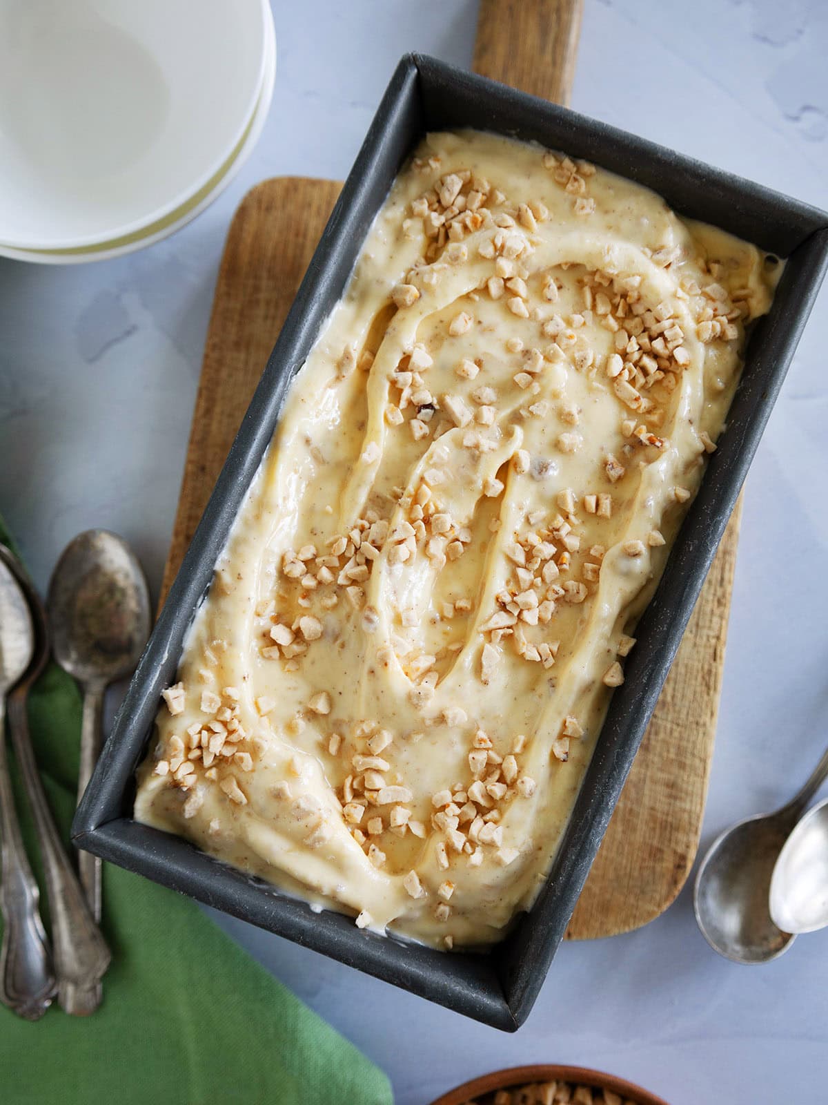 A pan of browned butter ice cream sprinkled with toffee.