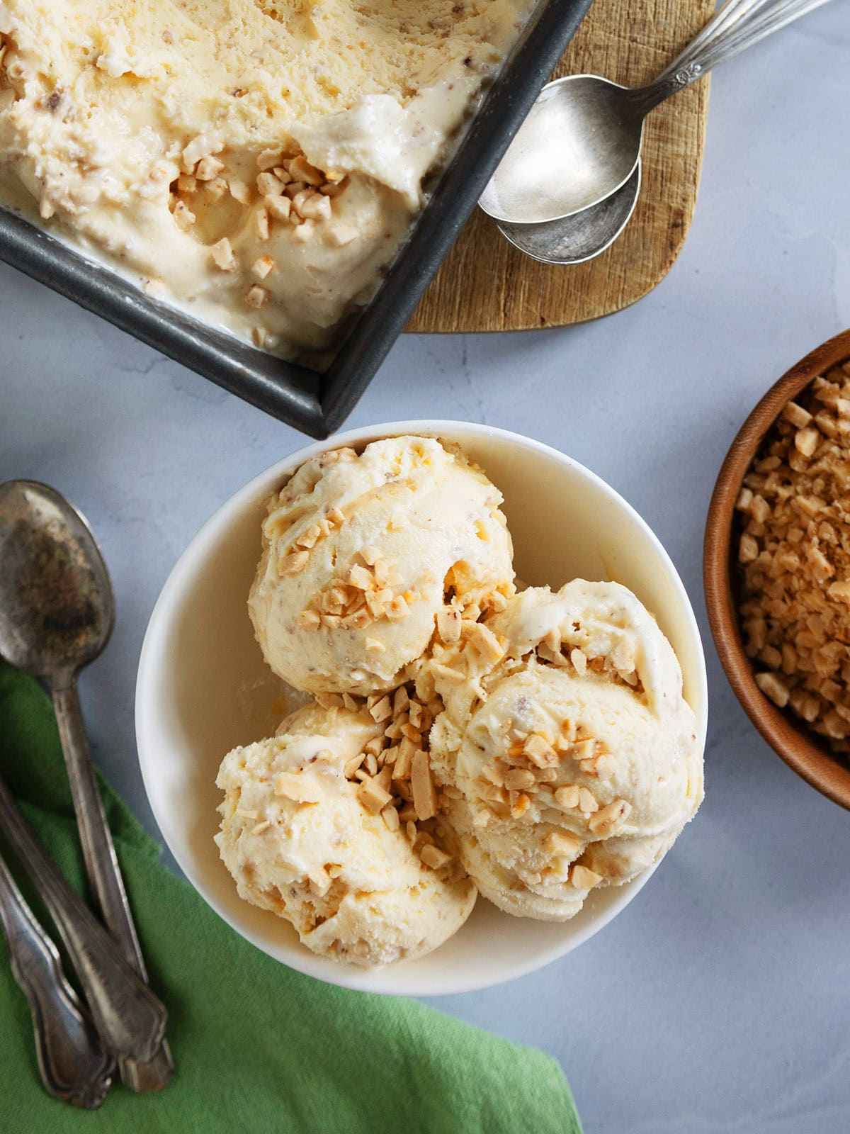Three scoops of browned butter ice cream in a small white bowl.