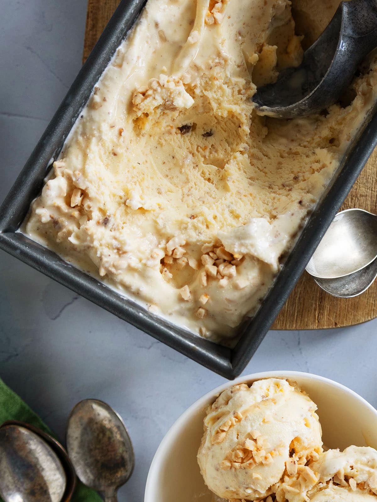 A pan of browned butter ice cream with several scoops removed.