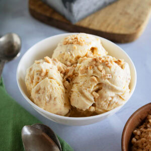 Several scoops of browned butter ice cream in a small white bowl.