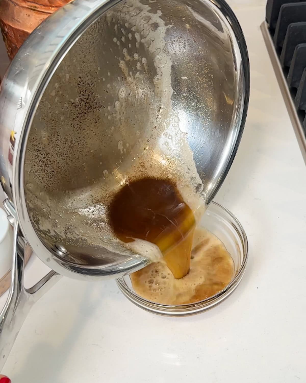 Pouring browned butter into a small bowl to cool.