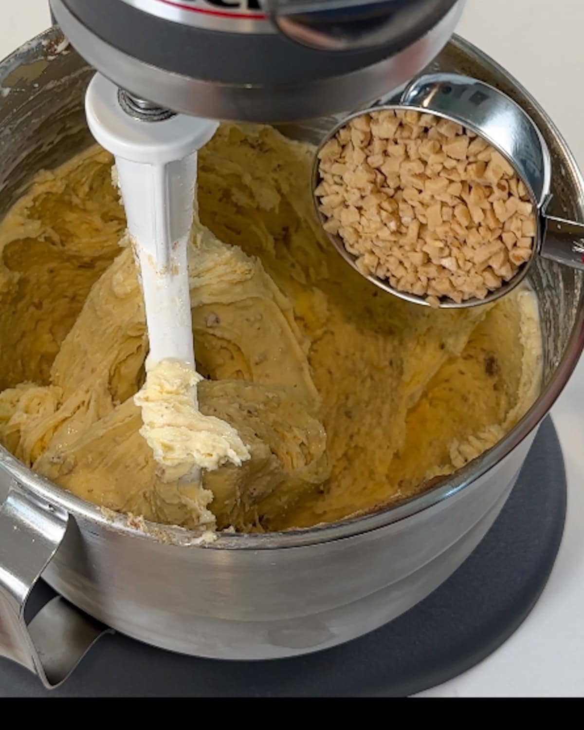 Mixing in toffee bits to browned butter ice cream in a mixing bowl.