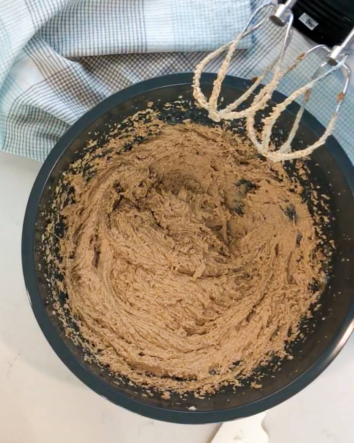 Butter, sugar, and eggs mixed together in a bowl for iced oatmeal cookies