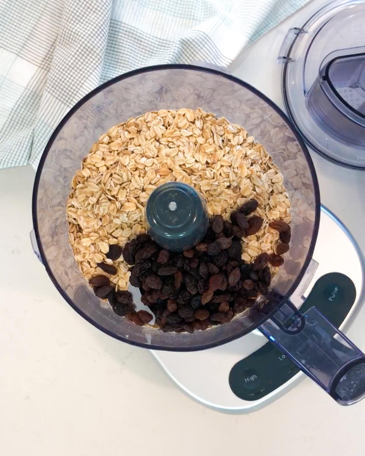 Oatmeal and raisins in food processor to start iced oatmeal cookies.