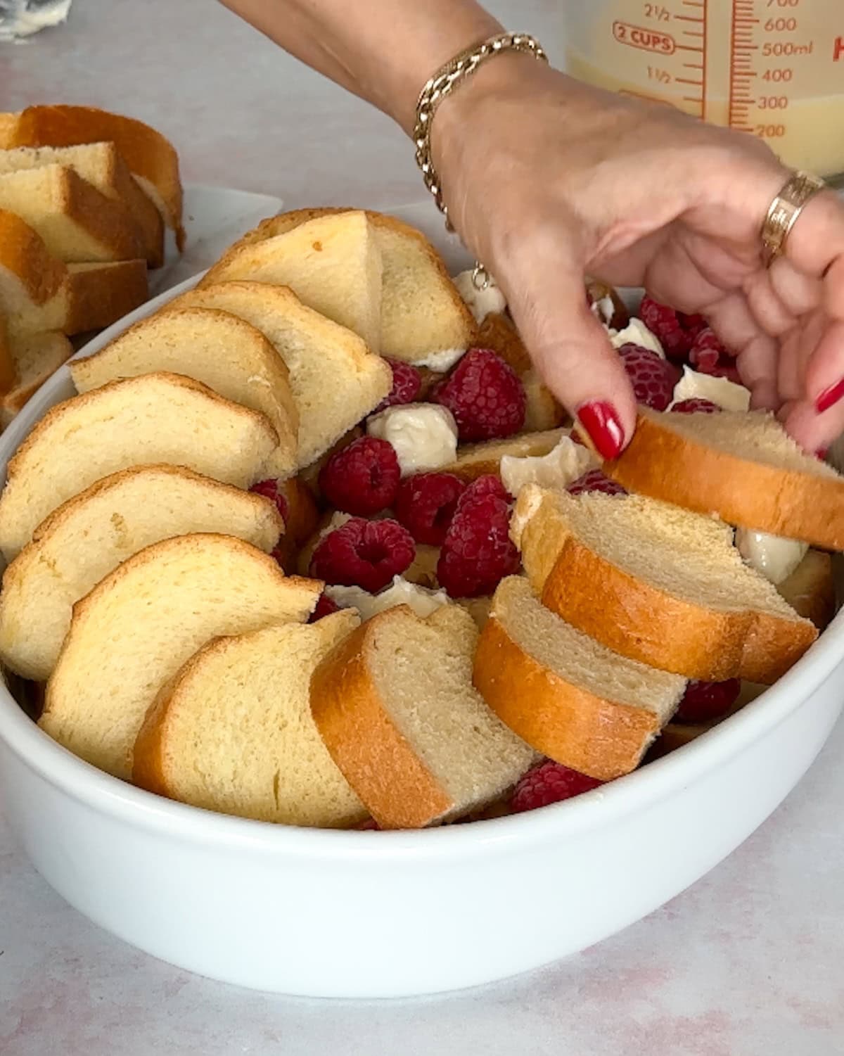 top layer of bread on raspberry bread pudding before baking.