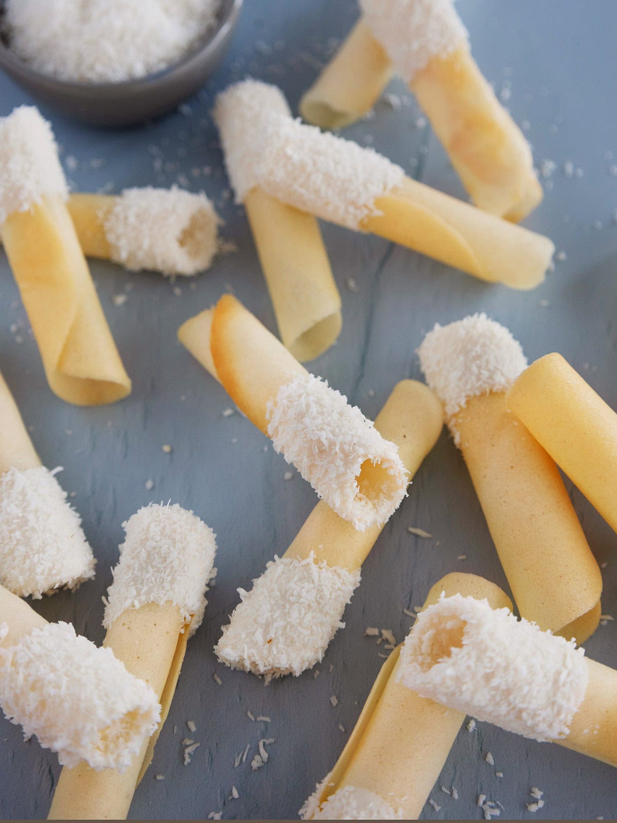 Several coconut pirouettes on a blue countertop.