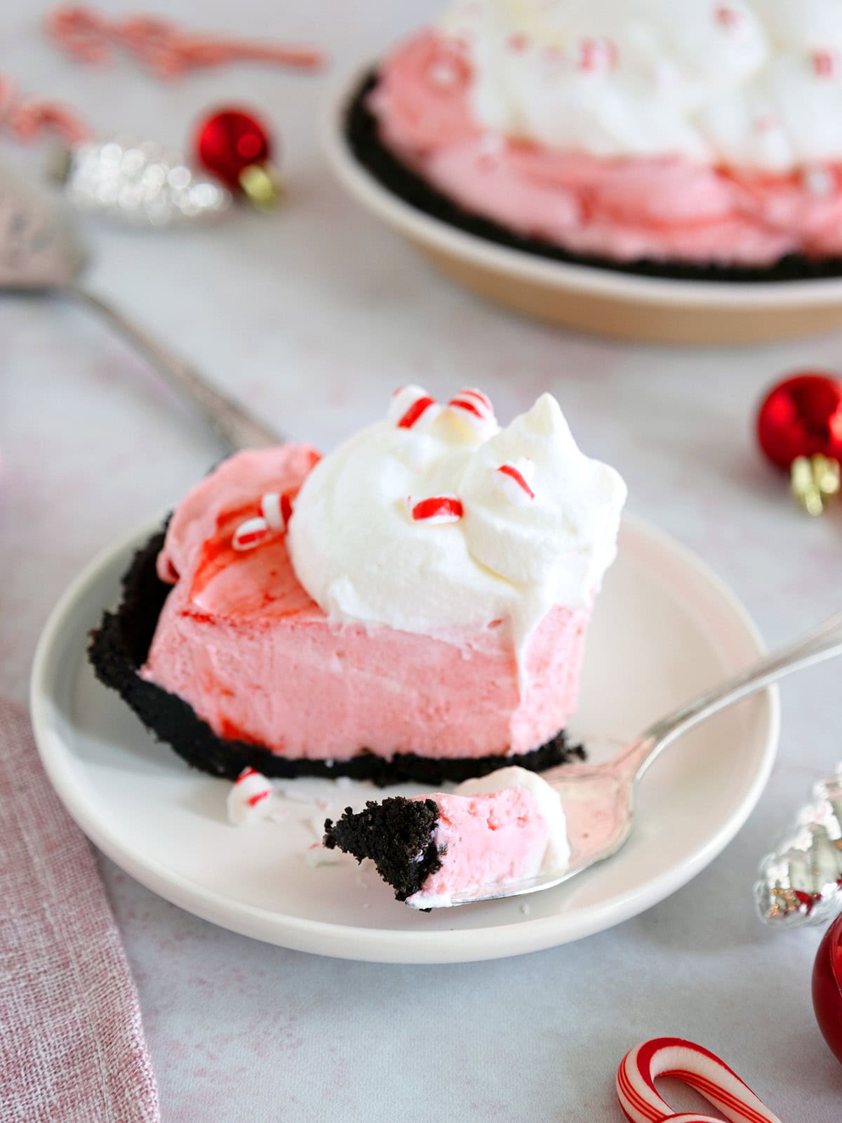 Close up of a slice of peppermint pie with a bite removed on a fork.