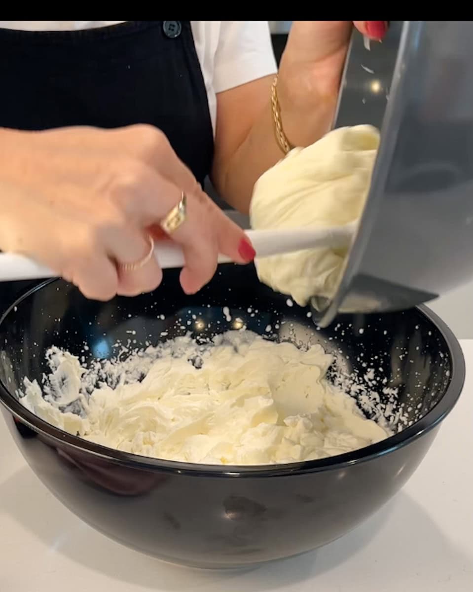 Spooning whipped cream cheese into whipped cream.
