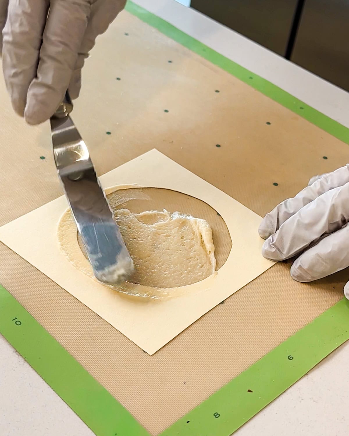 Spreading batter into a template to make a pirouette cookie.