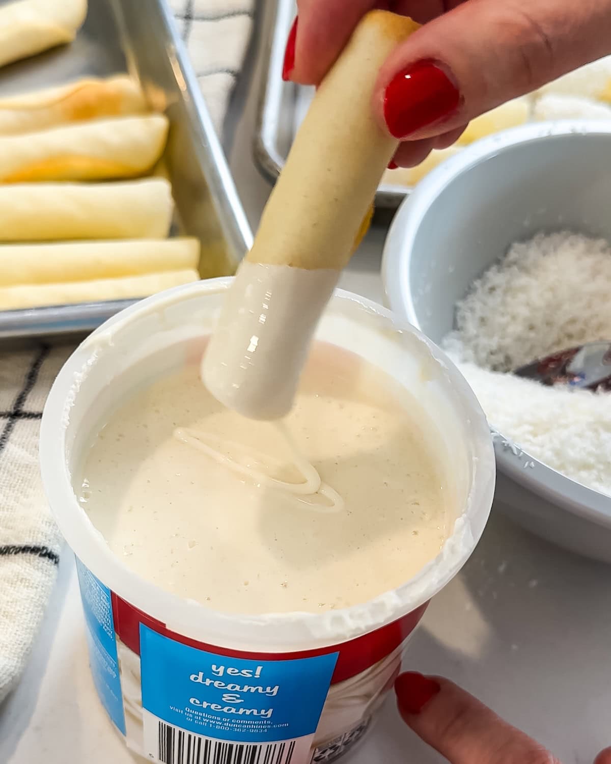 Dipping a pirouette cookie into warm frosting.