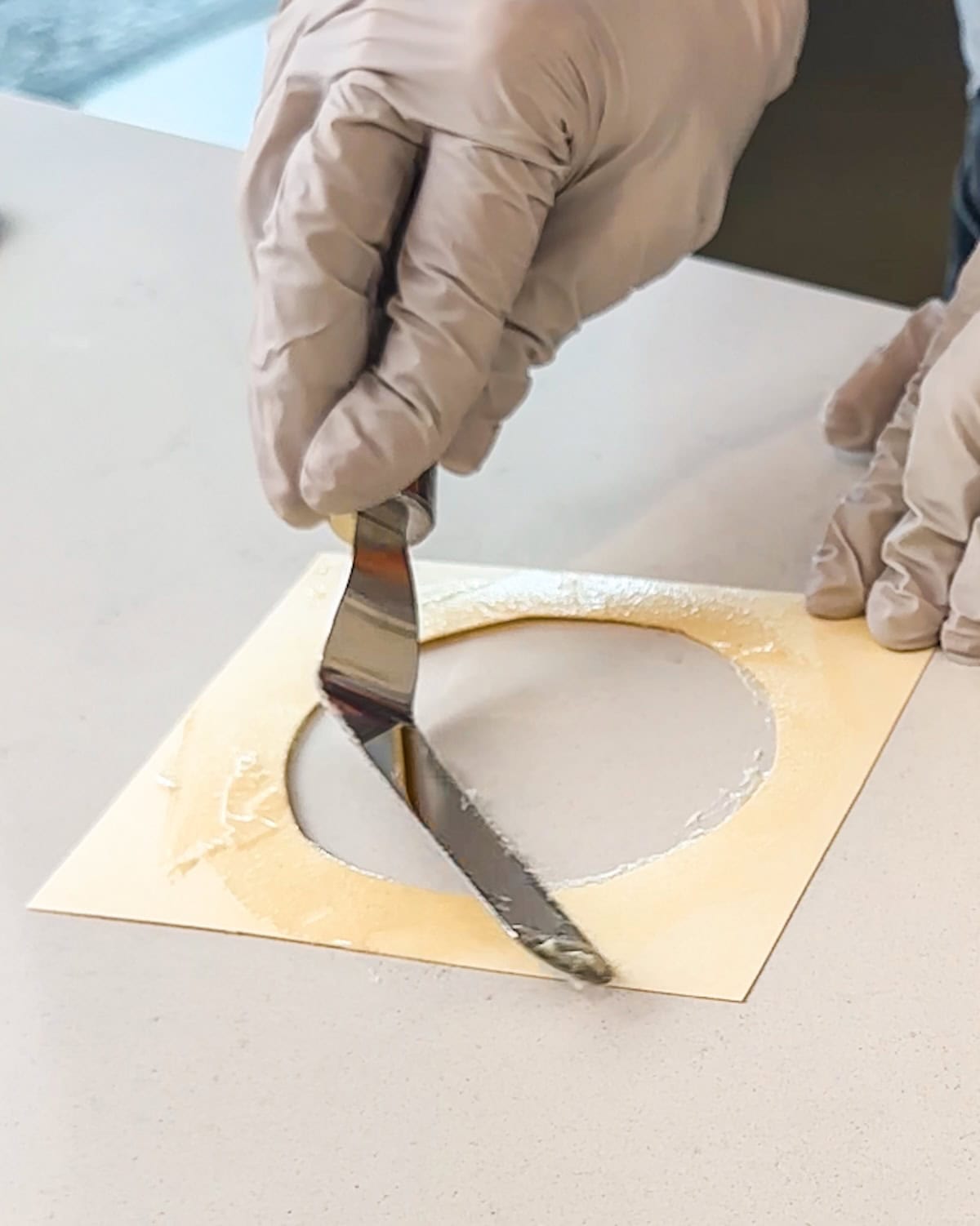 Cleaning off the template before spreading another pirouette cookie.
