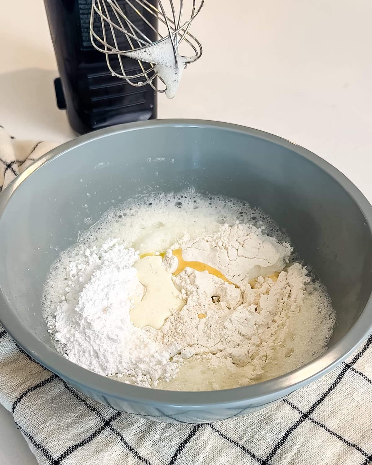 Adding flour, butter, cream, and salt to whipped sweetened egg whites.