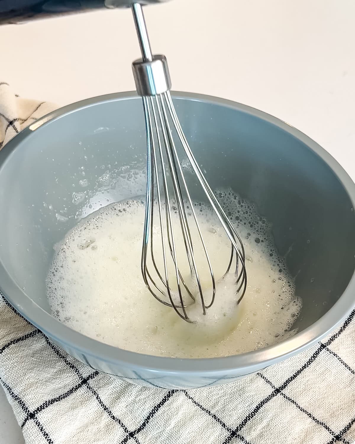 Whisked egg whites in a blue bowl.