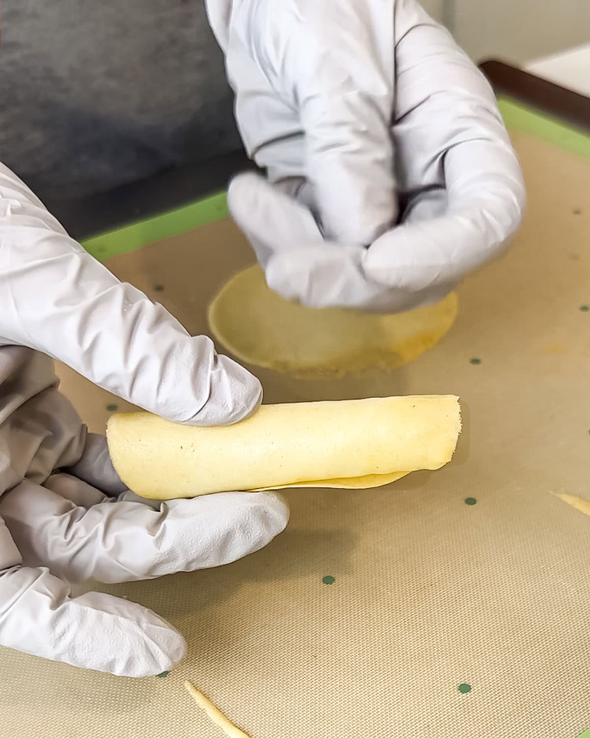 Holding a rolled pirouette cookie to set its shape.