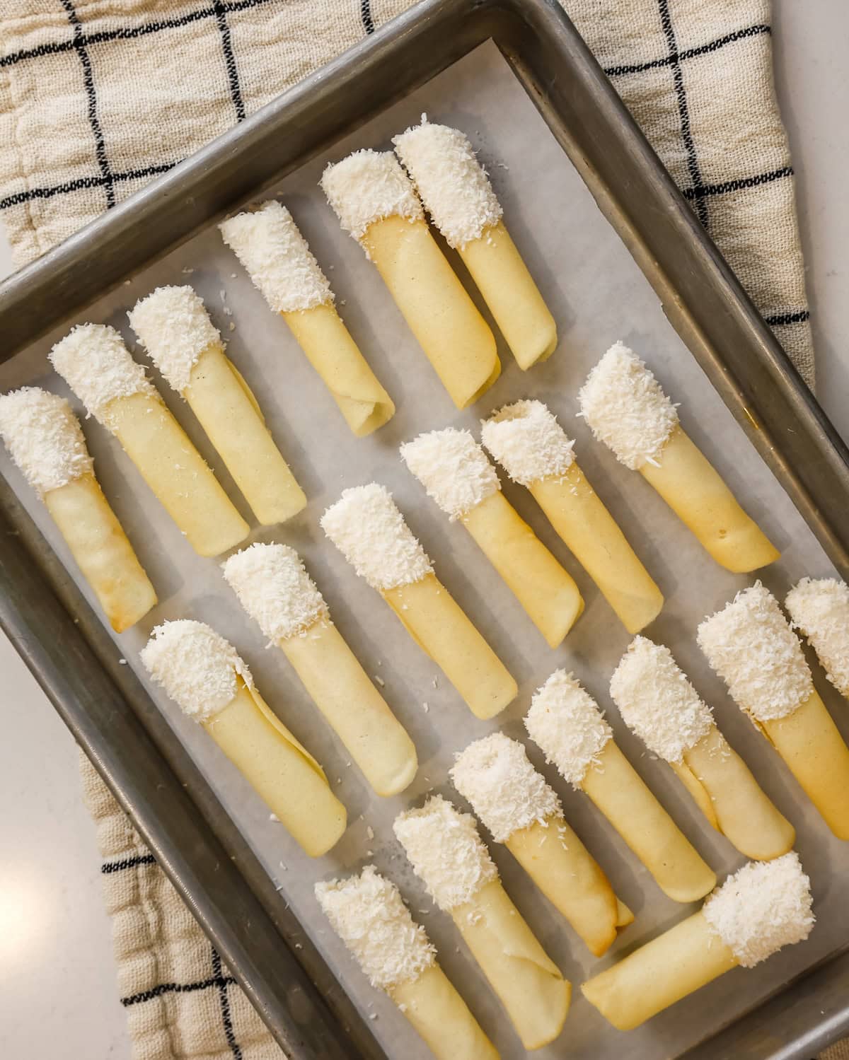 Decorated pirouette cookie drying on a tray.